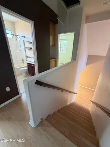 a view of an empty room with wooden floor and windows