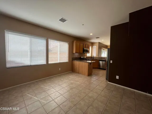 a view of kitchen with refrigerator and window