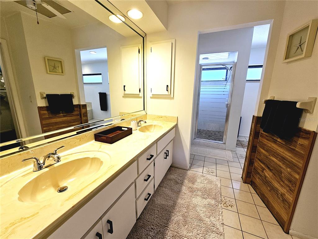 2411 Belle Road Englewood, FL 34223 - Photo 18 of 30 a spacious bathroom with a double vanity sink a mirror and a shower