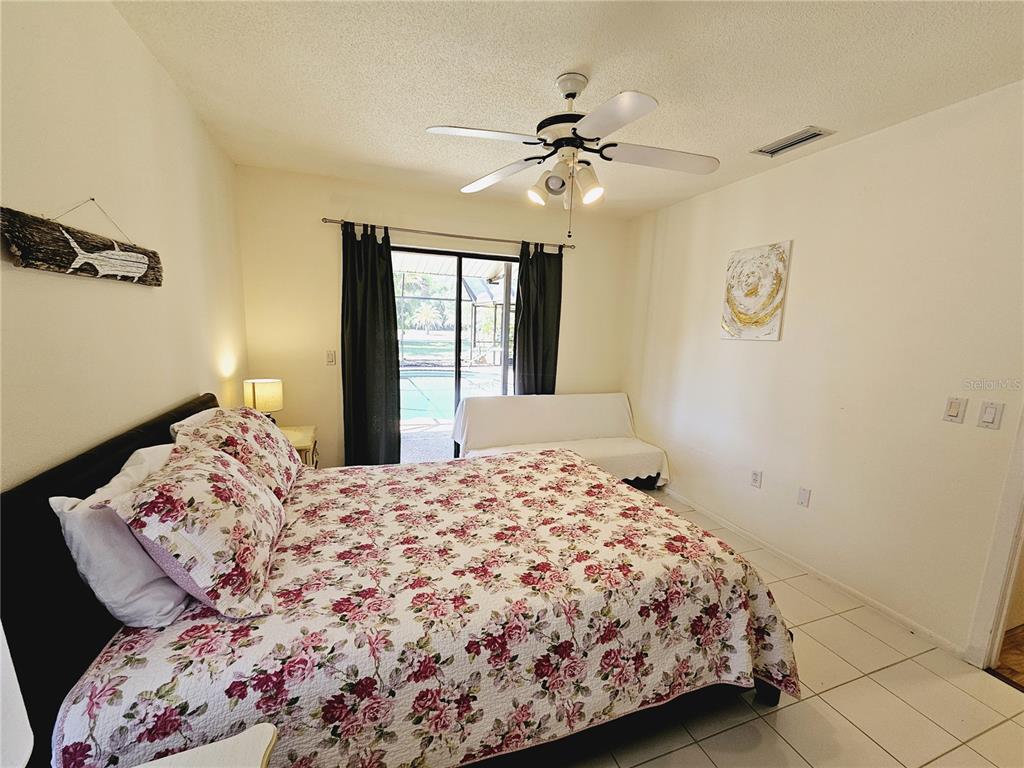 2411 Belle Road Englewood, FL 34223 - Photo 25 of 30 a bedroom with a bed and a chandelier