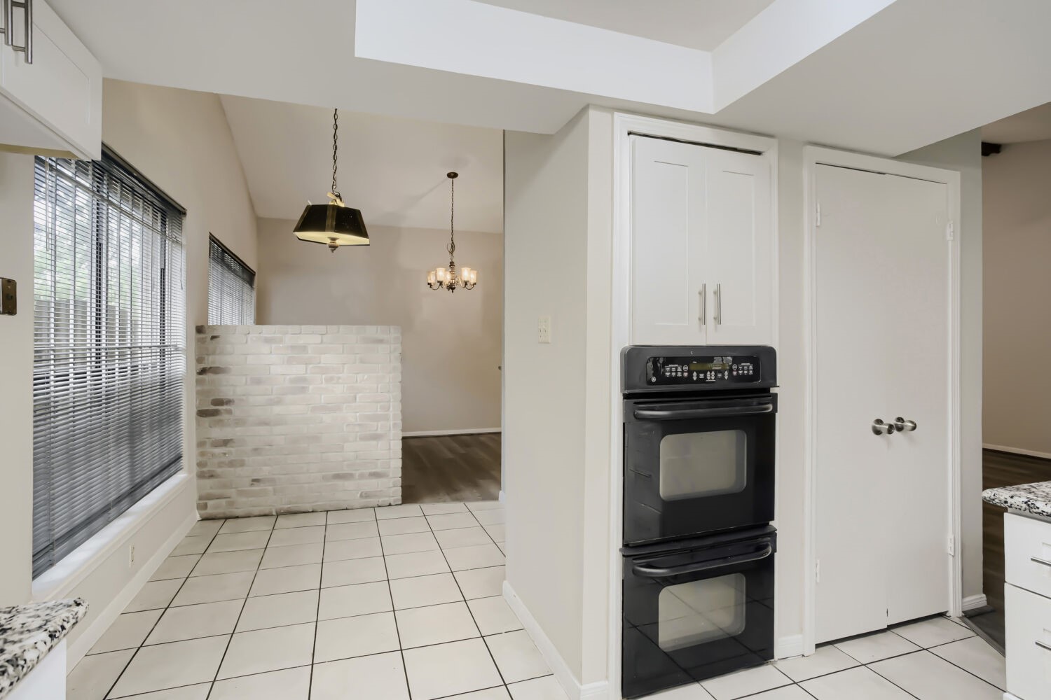 10103 Inwood Shadows Street Houston, TX 77088 - Photo 12 of 32 a view of a refrigerator in kitchen and an empty room with wooden floor