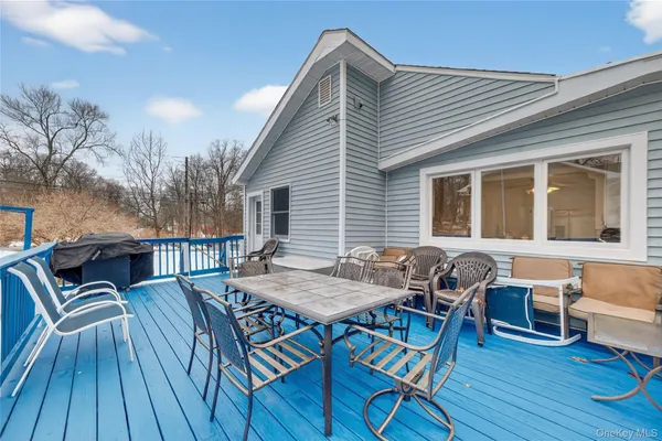 a view of a patio with table and chairs with wooden floor and fence