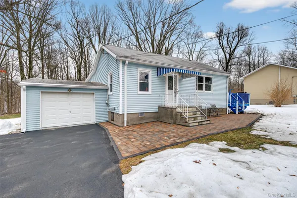 a front view of a house with a yard covered in snow