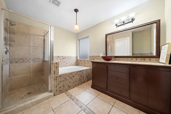 a bathroom with a granite countertop sink mirror and shower