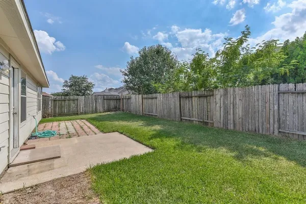 a view of a backyard with wooden fence
