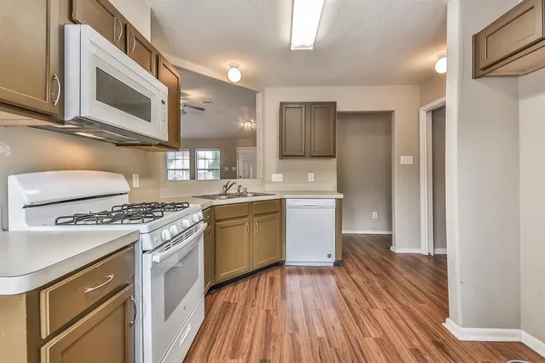 a kitchen with a sink wooden floor and stainless steel appliances