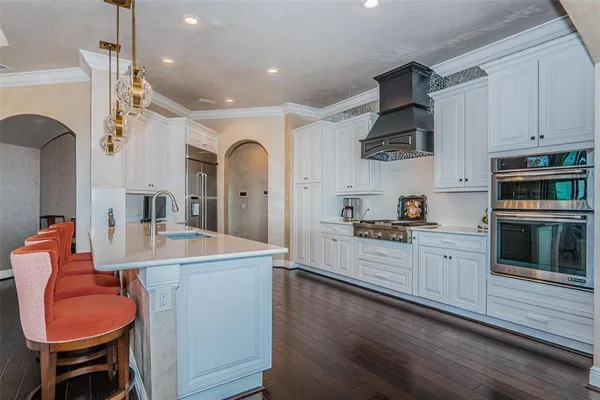 a kitchen with stainless steel appliances a dining table chairs and stove