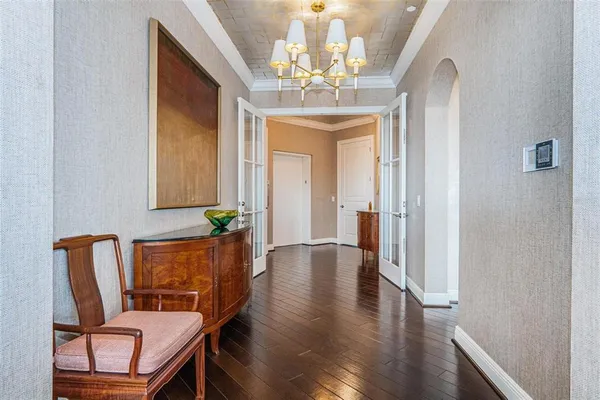 a living room with furniture a flat screen tv and a chandelier
