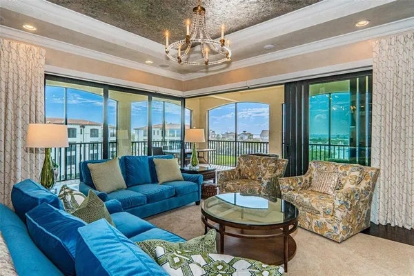 a living room with furniture a flat screen tv and kitchen view