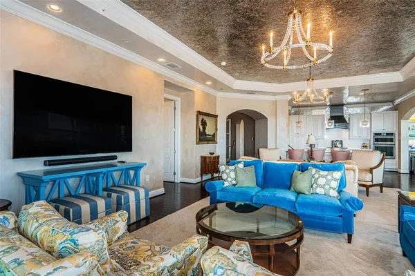 a dining room with wooden floor a chandelier a wooden table and chairs