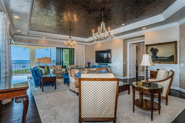 a living room with furniture and a chandelier