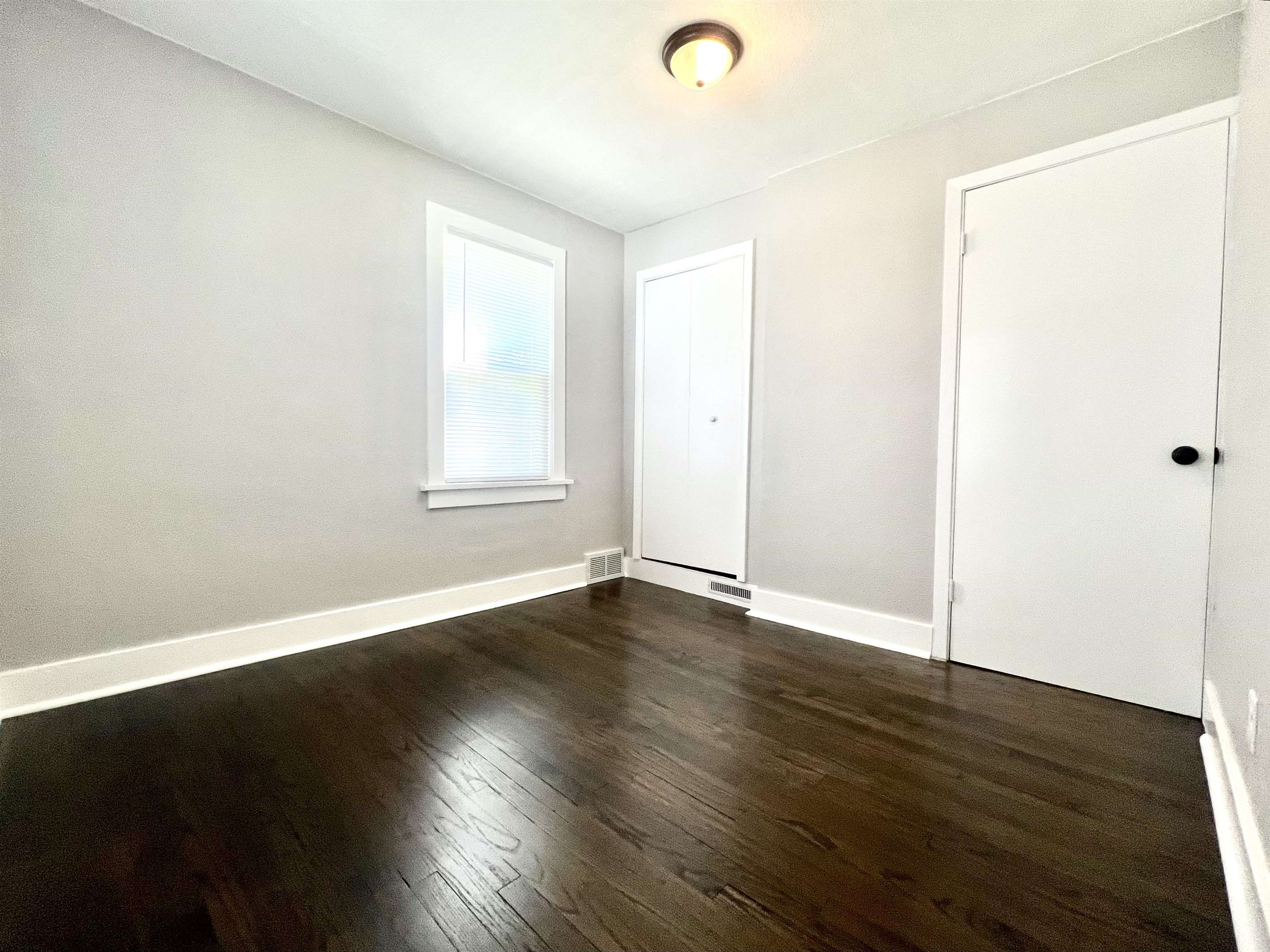 602 Barnum Road Rockford, IL 61109 - Photo 7 of 16 an empty room with wooden floor and windows