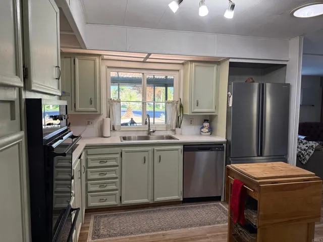 a kitchen with kitchen island granite countertop a sink stove and refrigerator
