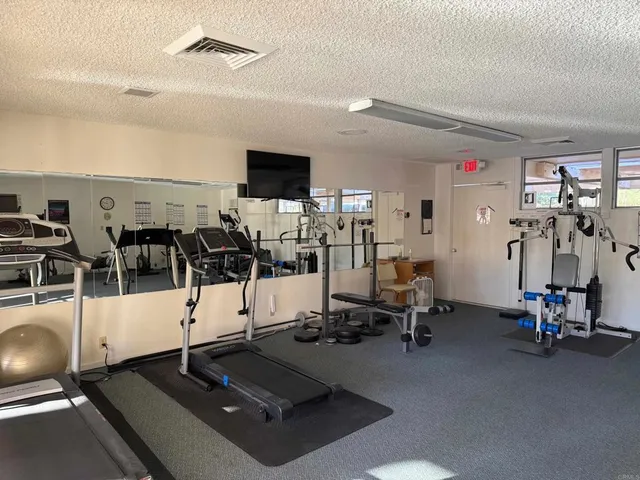 a living room with gym equipment and a table
