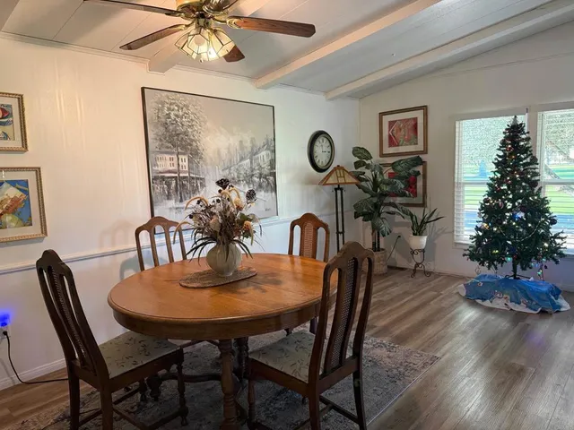 a dining room with furniture potted plants and wooden floor