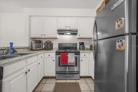 a kitchen with stainless steel appliances granite countertop a refrigerator sink and stove
