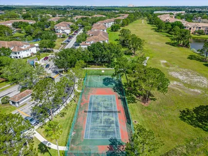 an aerial view of residential houses with outdoor space and trees all around