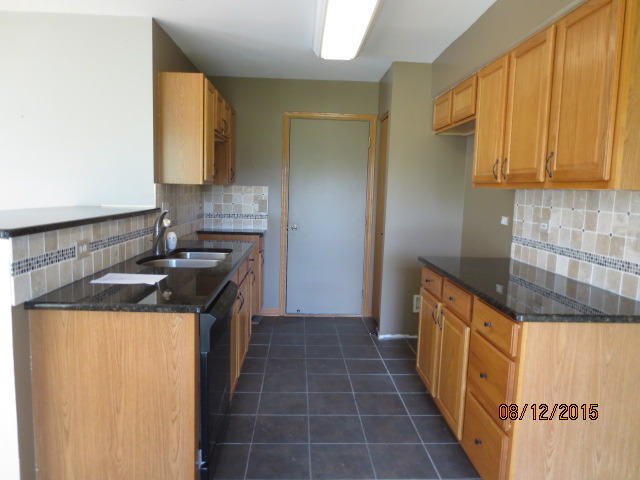 10549 Wakefield Lane Huntley, IL 60142 - Photo 7 of 19 a kitchen with a sink a stove top oven and cabinets
