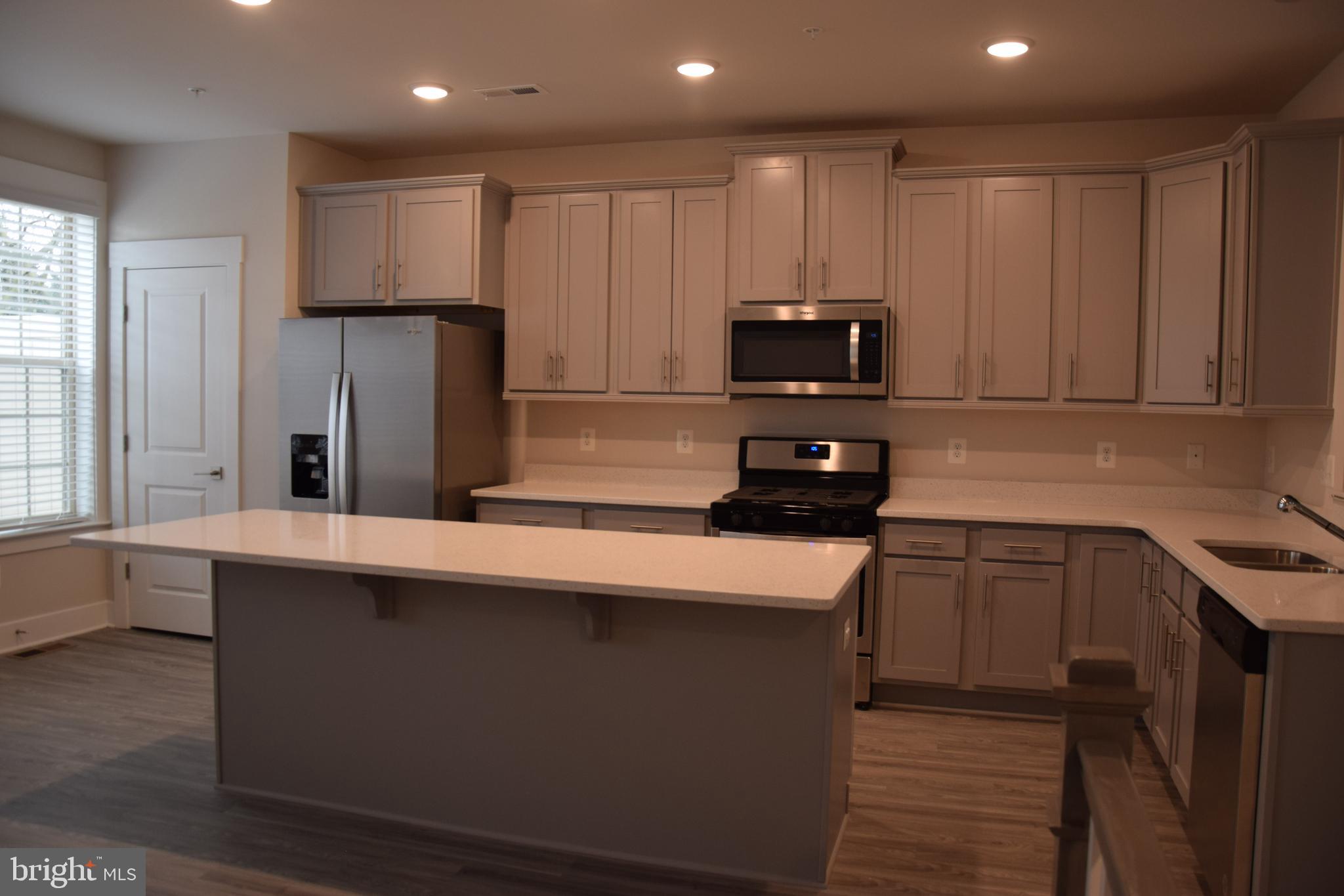 2915 Osprey Way Frederick, MD 21701 - Photo 3 of 27 a kitchen with stainless steel appliances a refrigerator a sink a stove a microwave and wooden cabinets