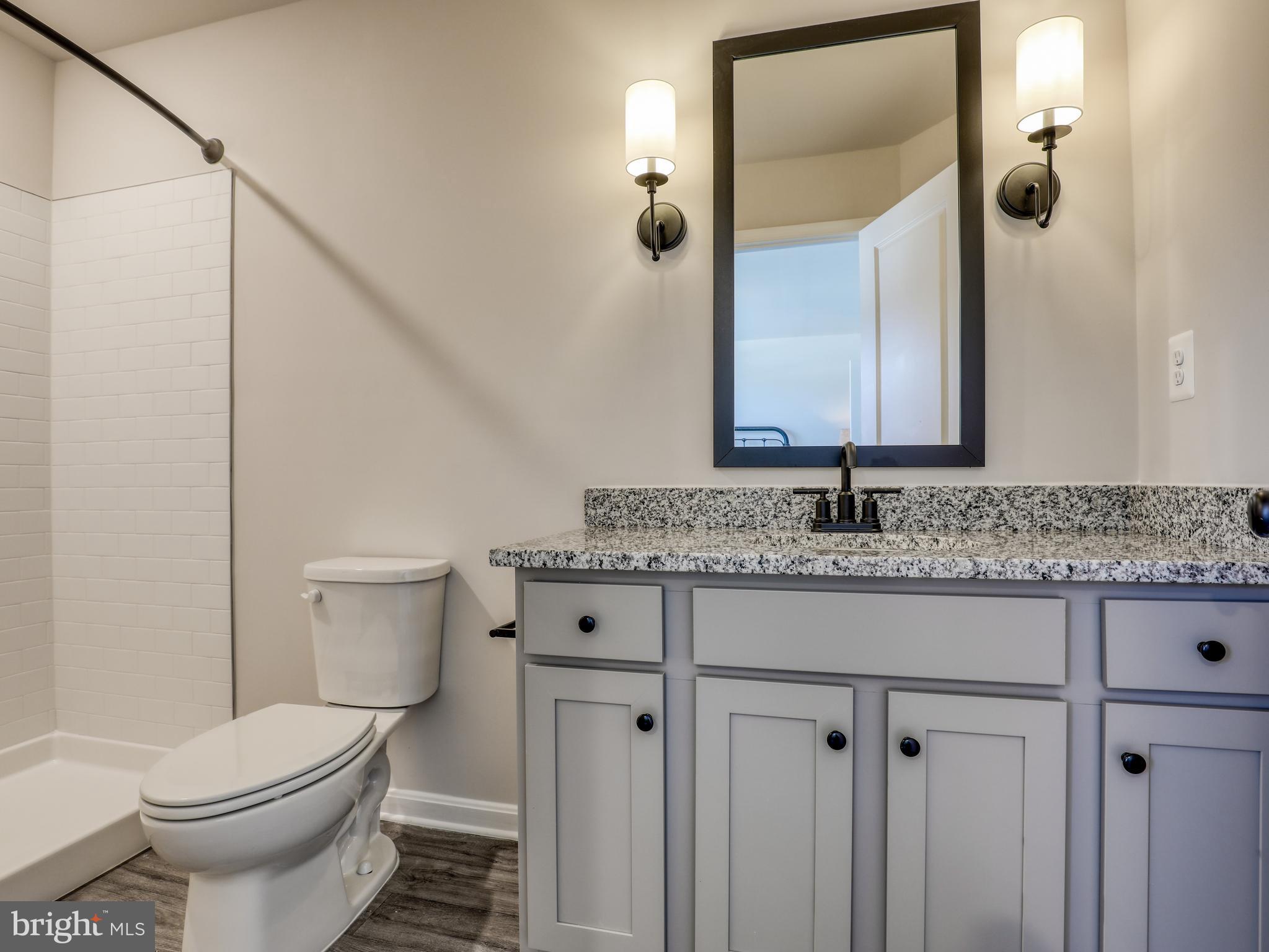 58 Thrower Road Hedgesville, WV 25427 - Photo 29 of 42 a bathroom with a granite countertop toilet sink and mirror