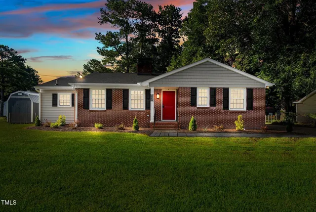 a front view of a house with a garden and yard