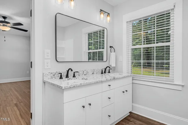 a view of an empty room with wooden floor fireplace and a window