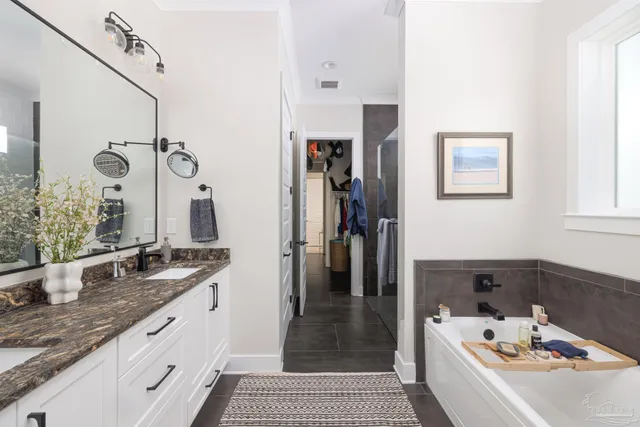a bathroom with a granite countertop sink a mirror and shower