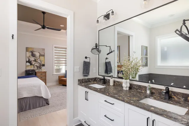 a en suite bathroom with a granite countertop sink and a mirror