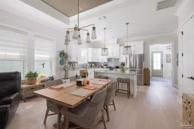 a view of a dining room and livingroom with furniture wooden floor a chandelier