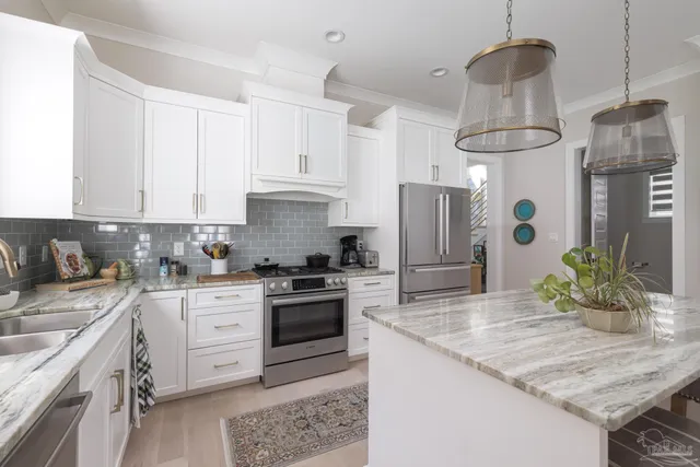 a kitchen with stainless steel appliances granite countertop a sink stove and refrigerator