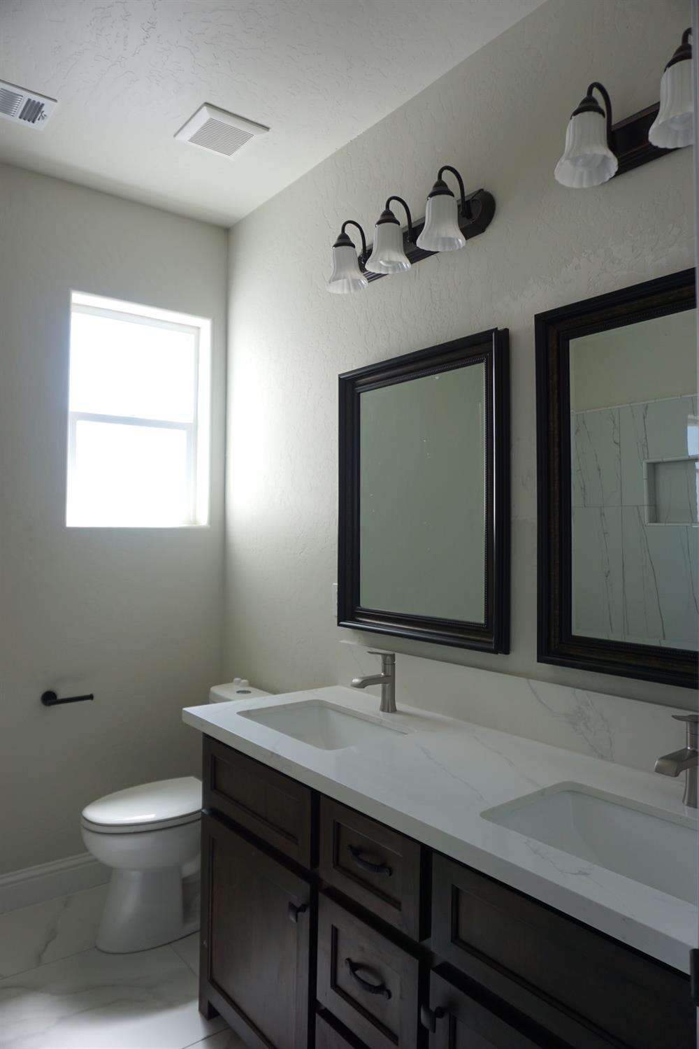 16398 Road 37 Madera, CA 93636 - Photo 14 of 23 a bathroom with a toilet sink and mirror