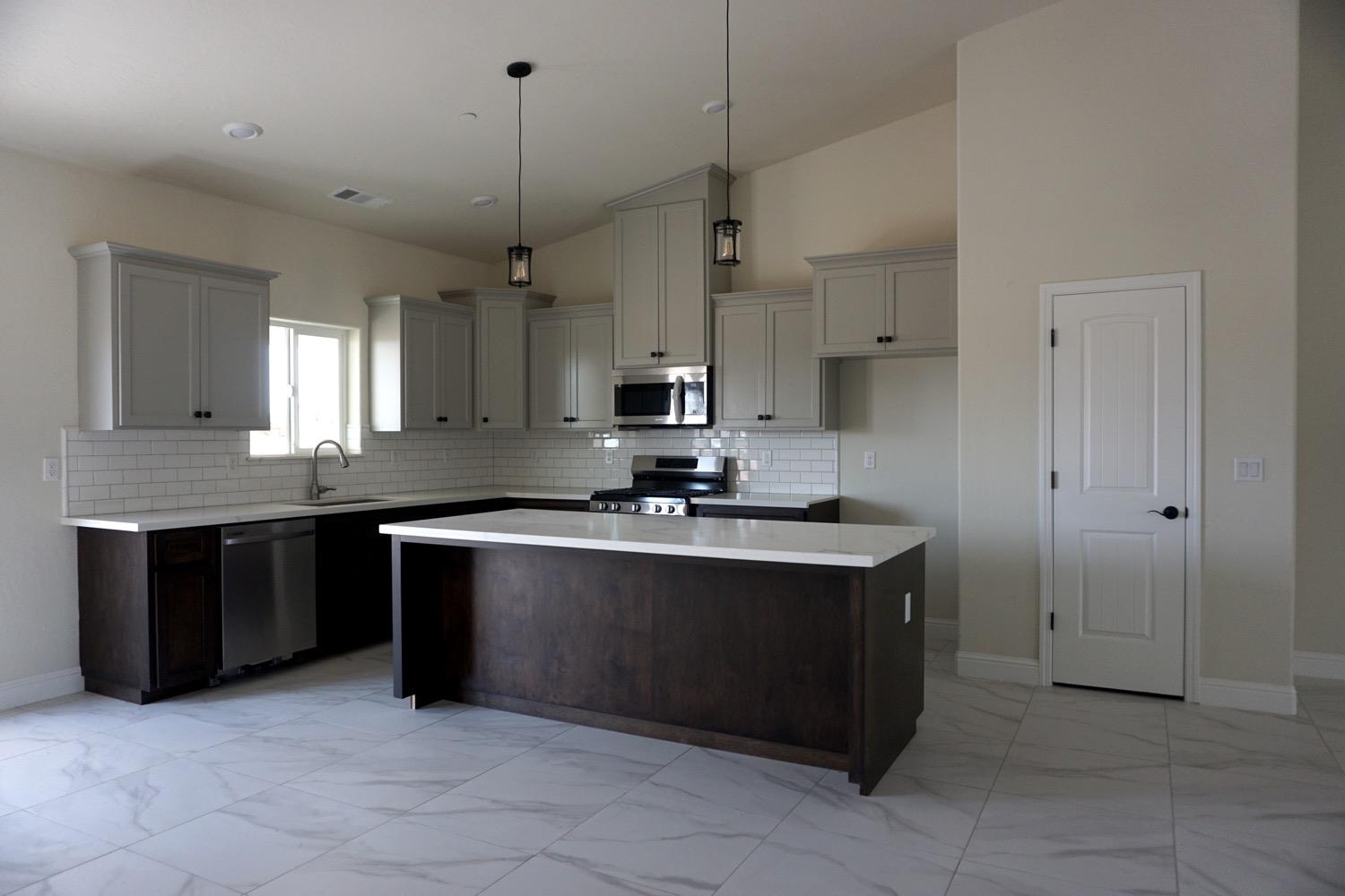 16398 Road 37 Madera, CA 93636 - Photo 5 of 23 a kitchen with stainless steel appliances a sink stove and cabinets