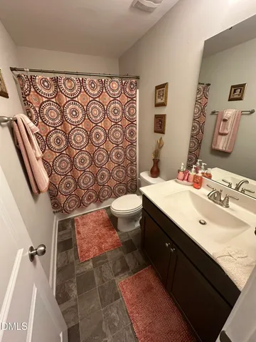 a view of a patio with table and chairs potted plants and floor to ceiling window