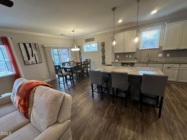 a living room with stainless steel appliances kitchen island granite countertop furniture wooden floor and a kitchen view