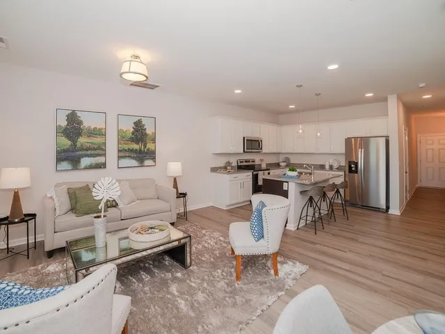 a living room with lots of furniture and kitchen view