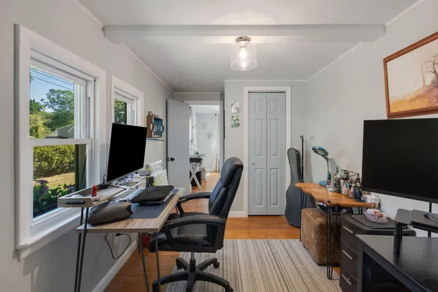a view of a workspace with furniture and a window
