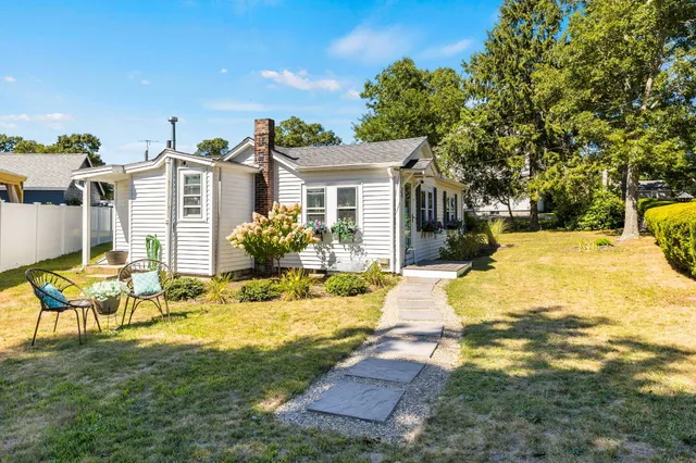 a view of a house with backyard and sitting area