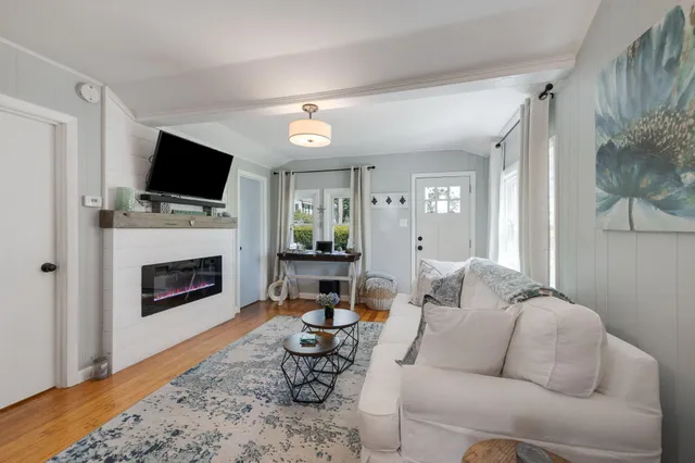 a living room with furniture a fireplace and a flat screen tv