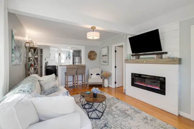 a living room with furniture a flat screen tv and a fireplace