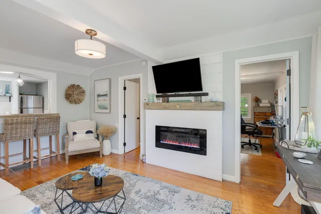 a living room with furniture a flat screen tv and a fireplace