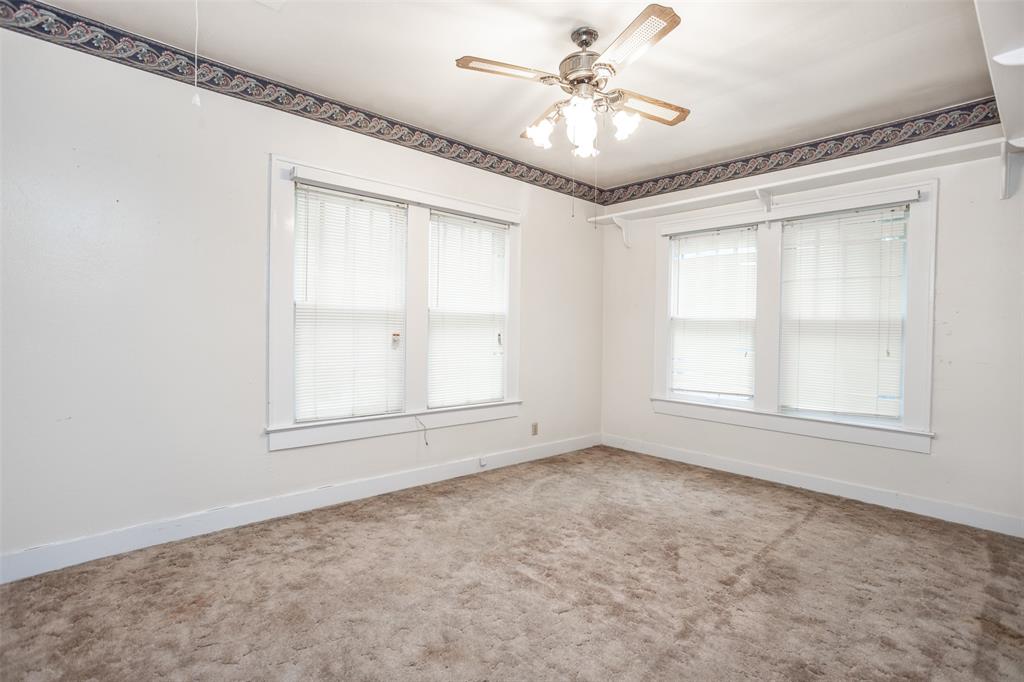206 Ritchey Street Gainesville, TX 76240 - Photo 25 of 36 an empty room with chandelier fan and windows