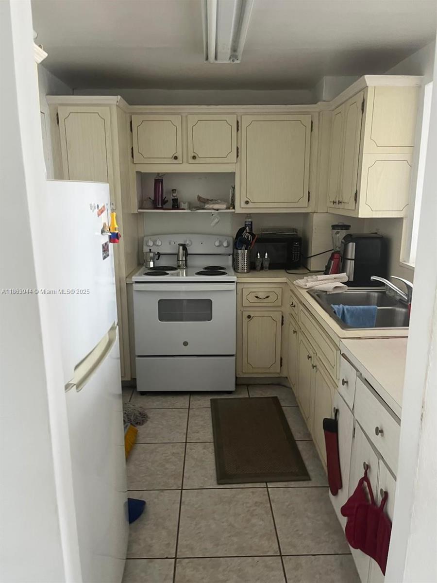 8000 Harding Avenue, Unit 5B Miami Beach, FL 33141 - Photo 4 of 6 a kitchen with a refrigerator sink and cabinets
