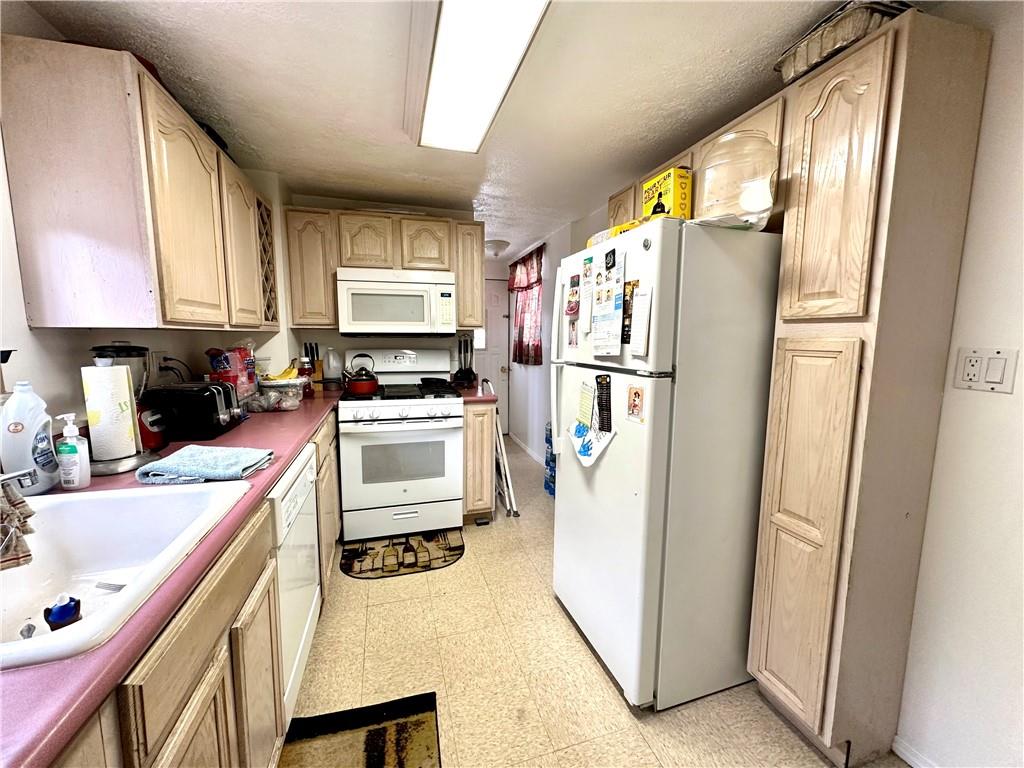 544 Woodward Avenue McKees Rocks, PA 15136 - Photo 7 of 13 a kitchen with a refrigerator a stove top oven a sink and dishwasher