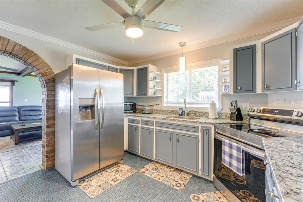 900 North Harbor Terrace Road Tavares, FL 32778 - Photo 13 of 58 a kitchen with stainless steel appliances granite countertop a stove a sink dishwasher a refrigerator and cabinets with wooden floor