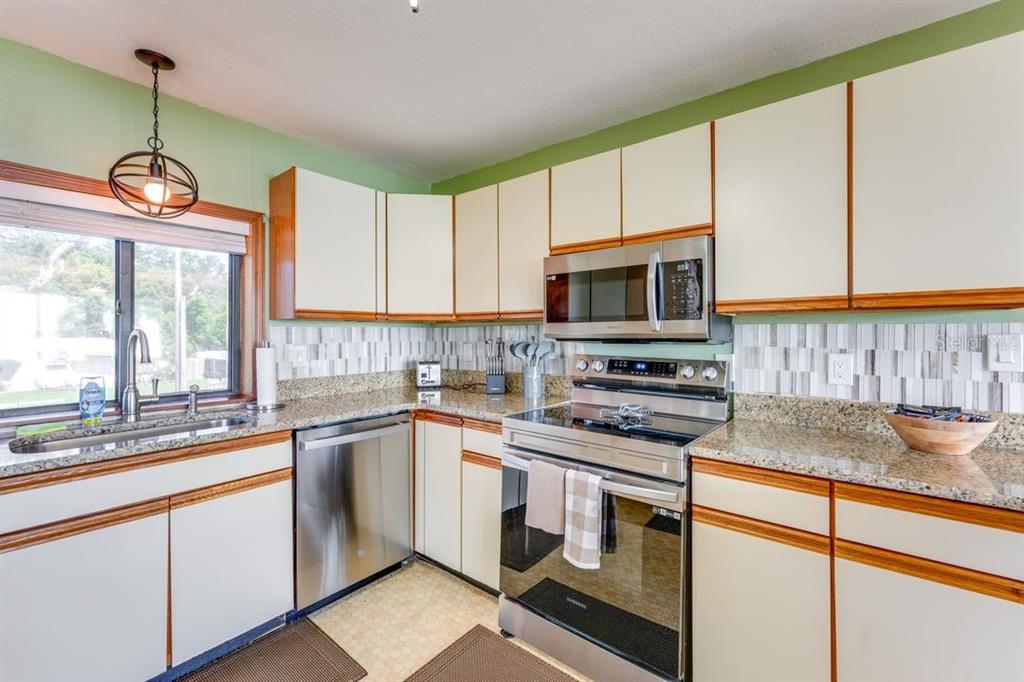 900 North Harbor Terrace Road Tavares, FL 32778 - Photo 32 of 58 a kitchen with a stove a sink and a microwave