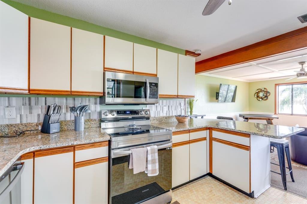 900 North Harbor Terrace Road Tavares, FL 32778 - Photo 33 of 58 a kitchen with stainless steel appliances granite countertop a stove a sink and a microwave