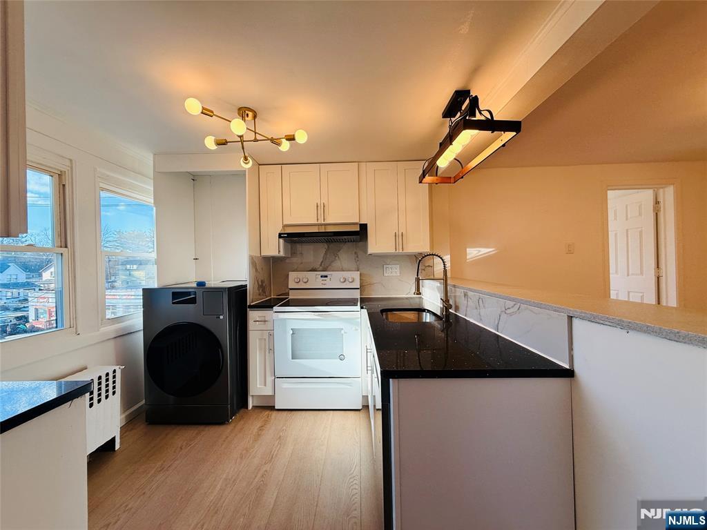 86 West Main Street, Unit 2 Bergenfield, NJ 07621 - Photo 5 of 12 a kitchen with kitchen island a stove a sink and a refrigerator
