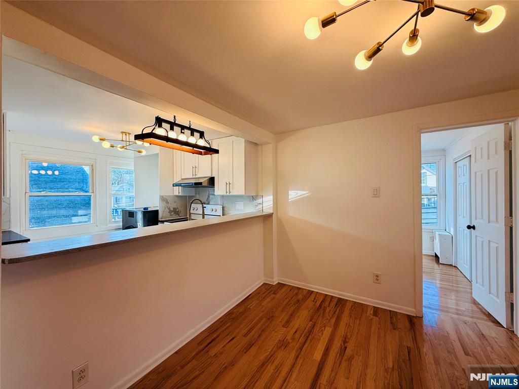 86 West Main Street, Unit 2 Bergenfield, NJ 07621 - Photo 6 of 12 a room with wooden floor and white walls