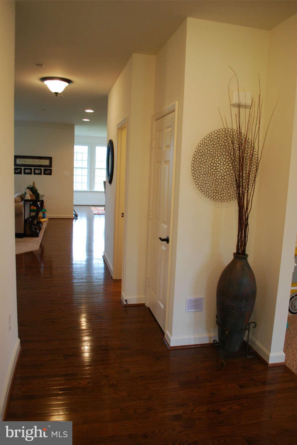7209 Talbot Run Road Mount Airy, MD 21771 - Photo 7 of 25 a view of a hallway with wooden floor and furniture