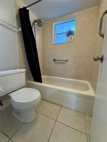 a spacious bedroom with a bed and a flat screen tv